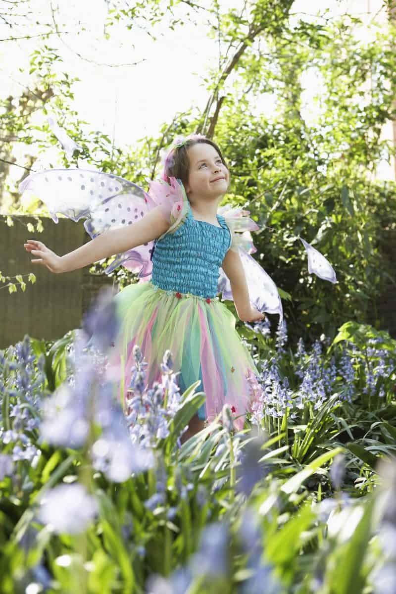 Gardening activities for preschoolers - girl dancing in garden in a fairy costume.