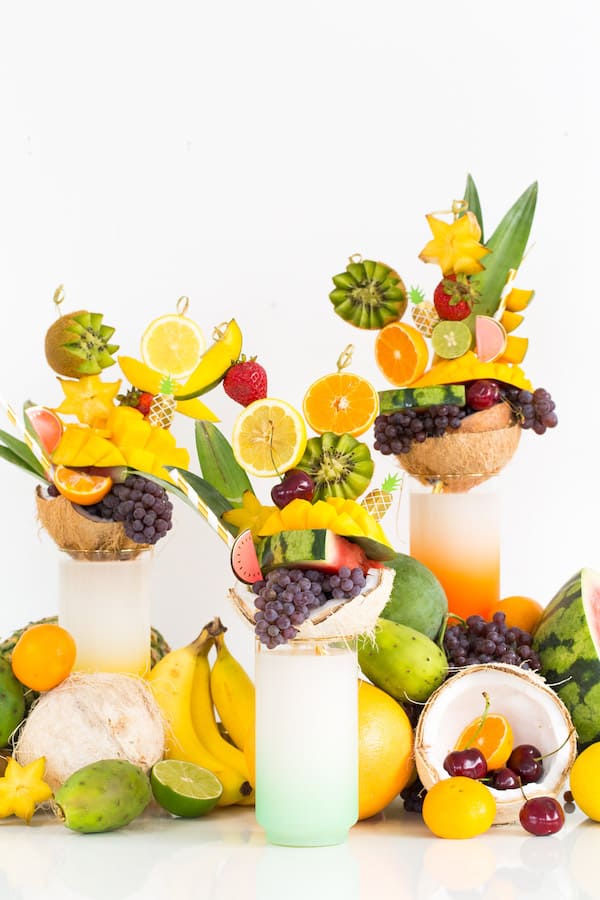 Skewers of tropical fruit on top of milkshake glasses