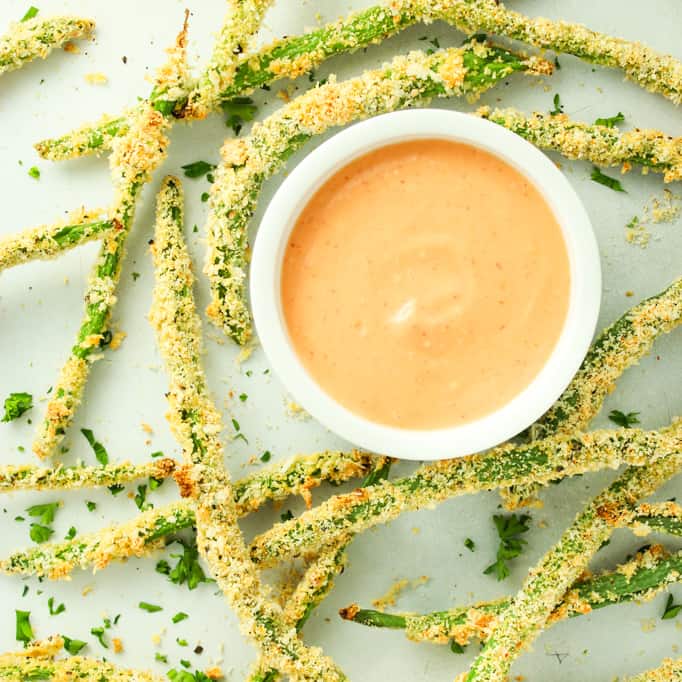 crispy baked green bean fries on white plate with sauce