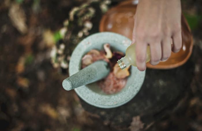 Dripping EO into mortar and pestle. Article with tips for safe essential oil use around kids